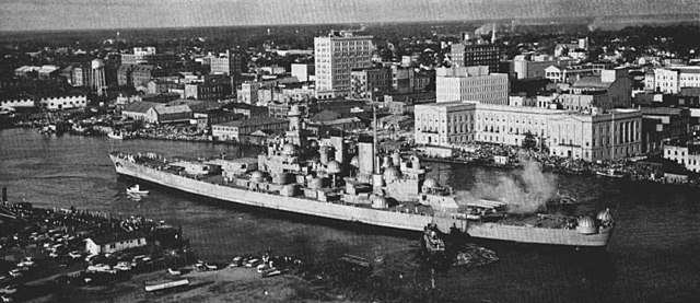 The decommissioned USS North Carolina (BB-55) being towed up the Cape Fear River, Wilmington, NC, October 1961. Photo by U.S. Navy, published in *U.S. Navy All Hands* magazine, December 1961. Public Domain. Source: https://commons.wikimedia.org/wiki/File:USS_North_Carolina_(BB-55)_being_towed_up_Cape_Fear_River.jpg